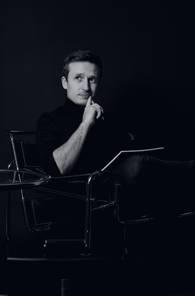 Schwarz-weisses Bild von Gianluca Cataldo, Geschaeftsfuehrer von Mindcon, auf einem Schreibtischstuhl, der sich Gedanken ueber die Selbststaendigkeit am Bodensee macht